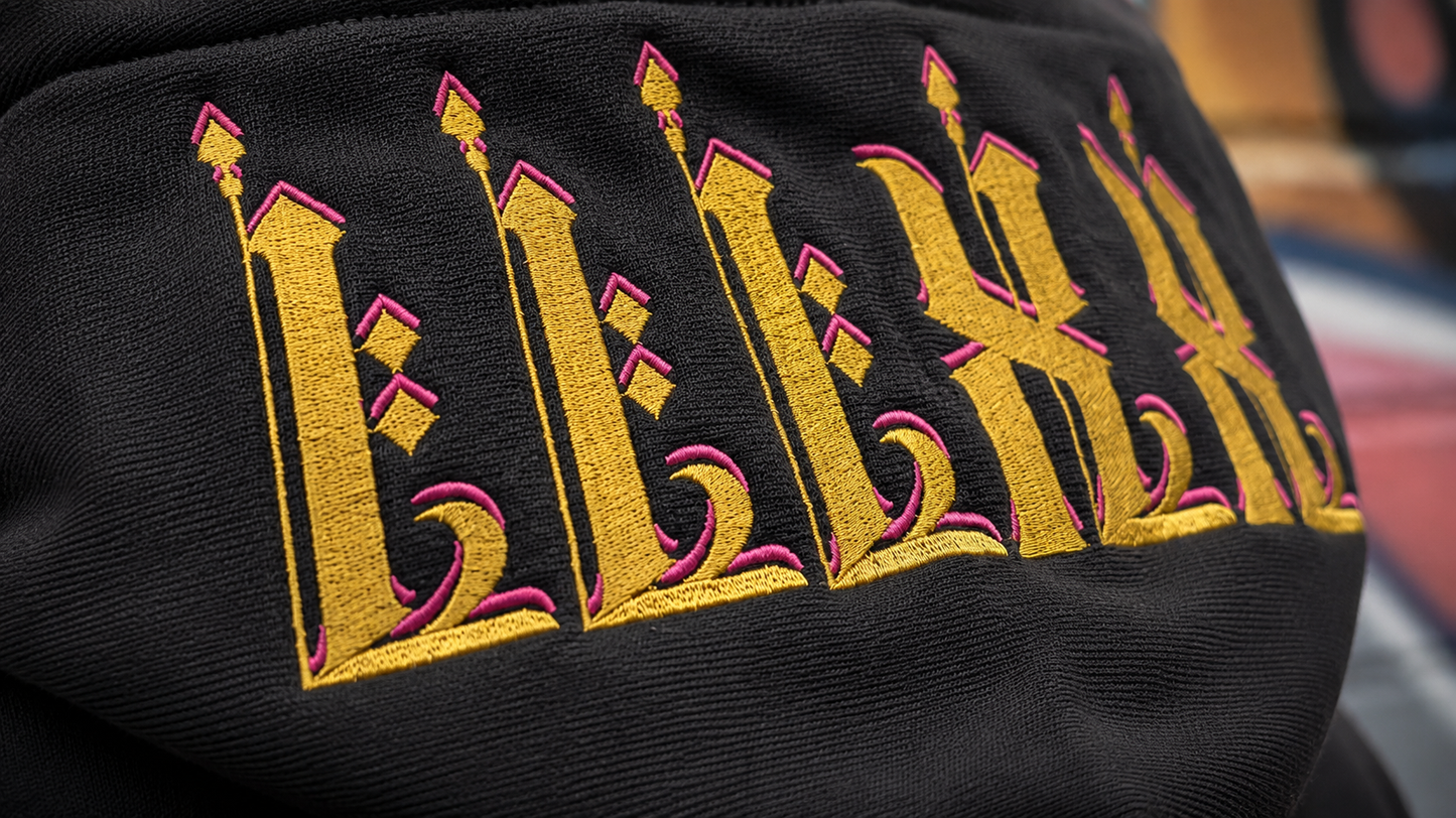 Close up view of 23Ravens hoodie embroidery on hood with large gothic gold graphic print