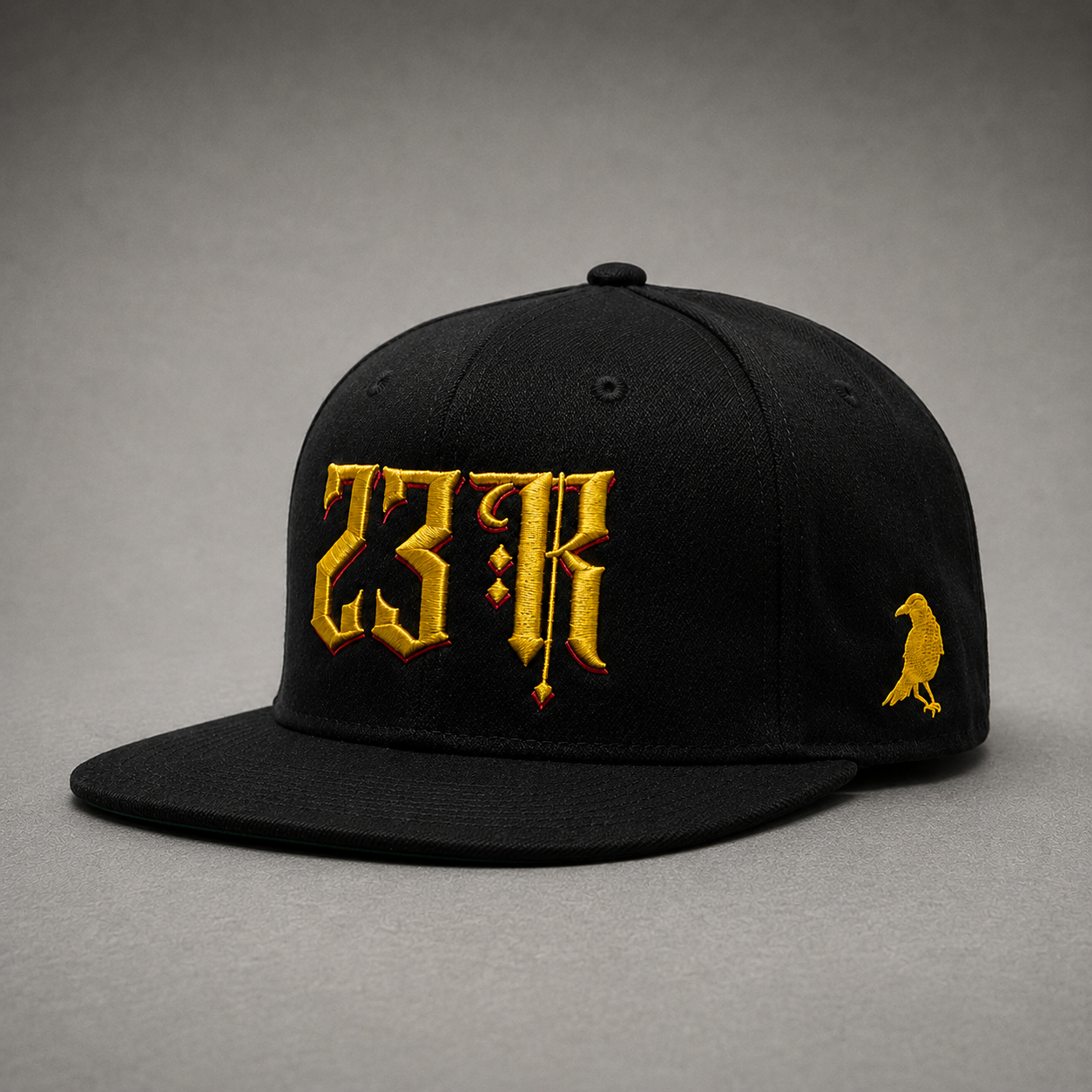Angled view of black 23Ravens snapback cap with gold gothic embroidery and raven logo