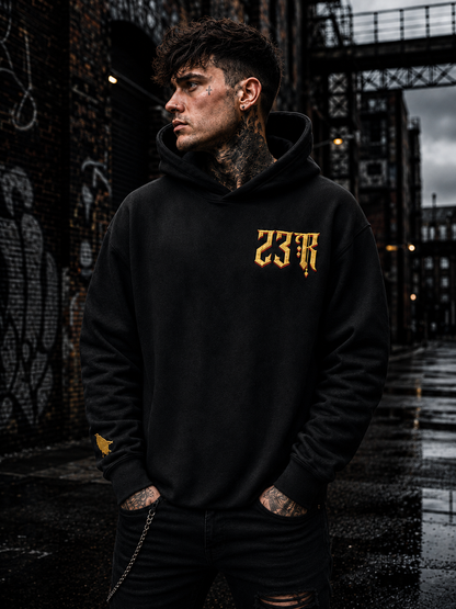 Front view of black 23Ravens oversized hoodie with gold gothic chest embroidery
