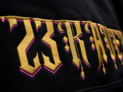 Close up view of 23Ravens hoodie embroidery with large gothic gold graphic print
